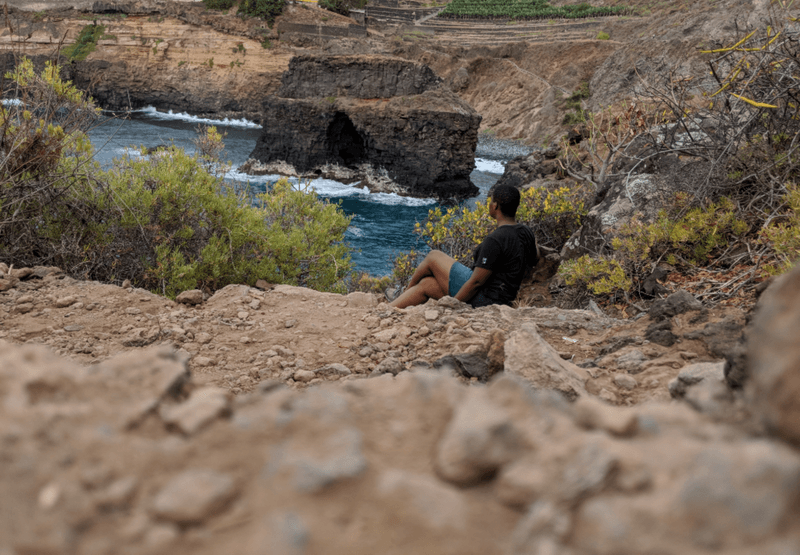 photo of Keziyah sitting on some rocks in Puerto de la Cruz, Tenerife